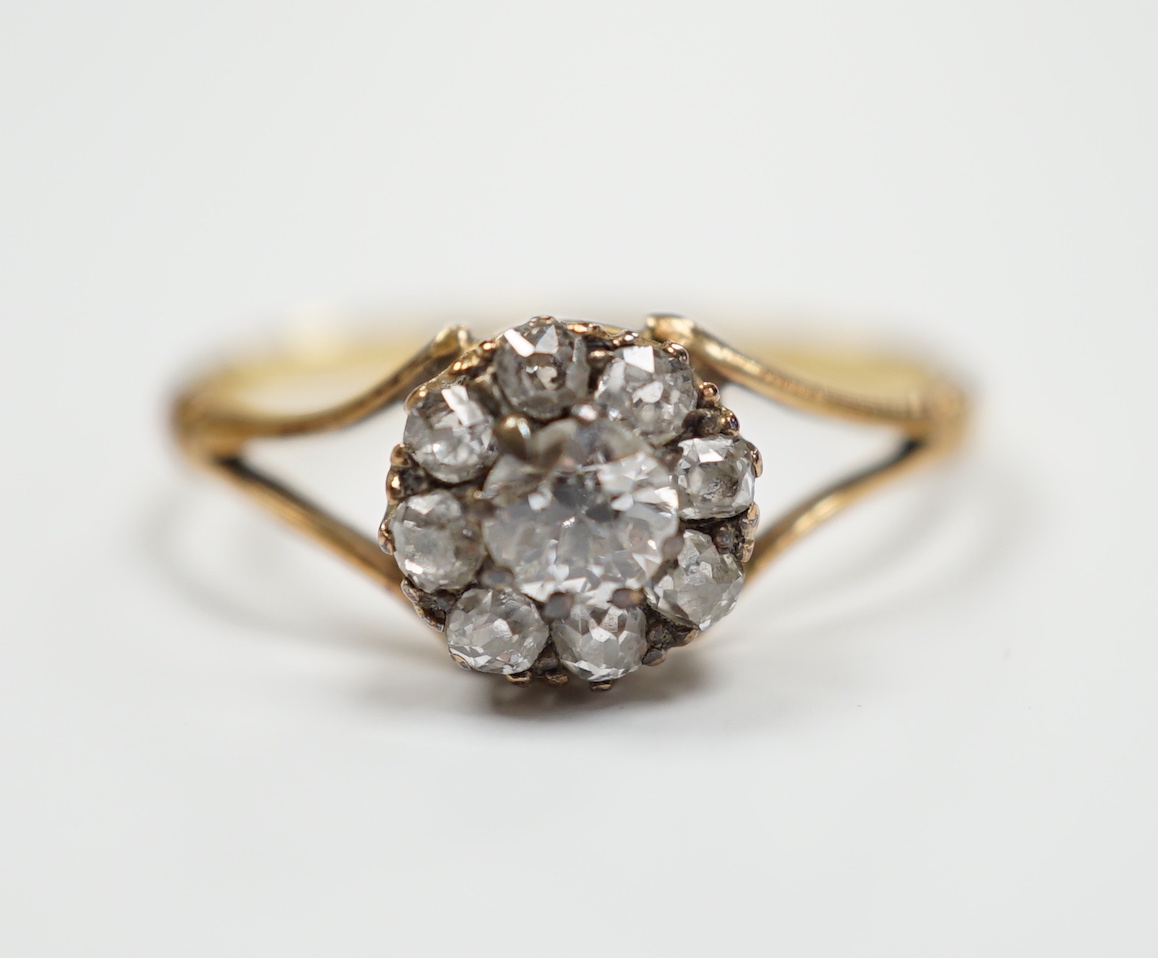 An early 20th century 18ct and old round cut diamond set circular cluster ring, size Q, gross weight 2.7 grams.